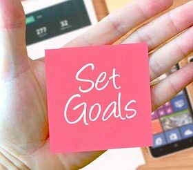 「Set Goals」と書かれた紙とスマホ、レジュメ