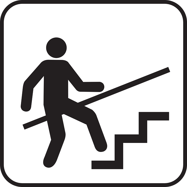 手すりにつかまりながら階段を上る人