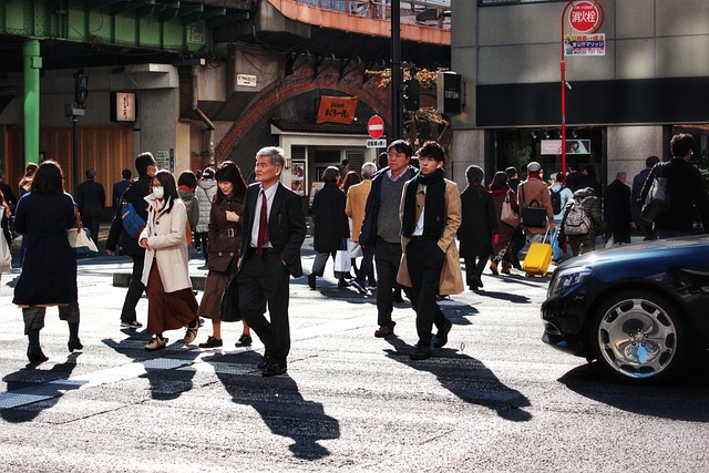 横断歩道を歩く人たちとその手前で止まる車