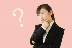 「？」の文字とスーツ姿の女性