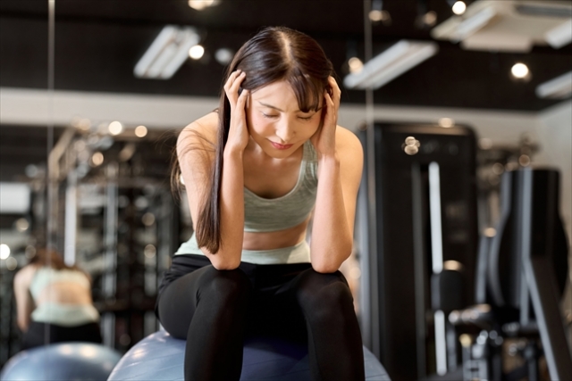 ジムで頭を抱える中高年女性