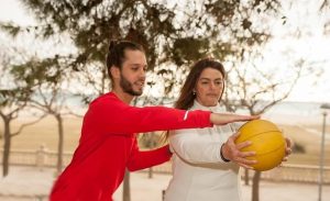 ボールを持つ女性の肩に手をかける男性