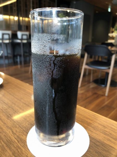 透明なグラスに入った黒い液体を正面からみたところ