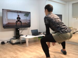 モニターを見ながら腰を落とす男性