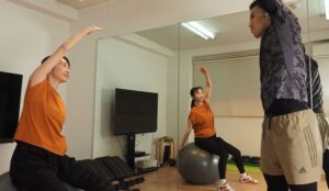 片手を上げながら男性と女性が向き合っている