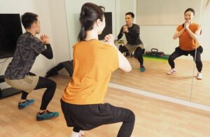 鏡に向かって中腰になる女性と男性
