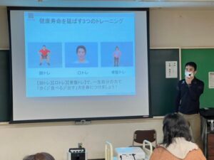 画像が投影されたスクリーンの前で話す人