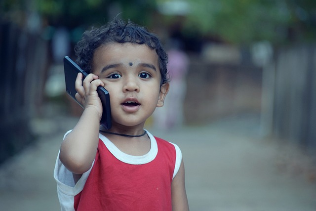 スマホを耳に当てる子ども