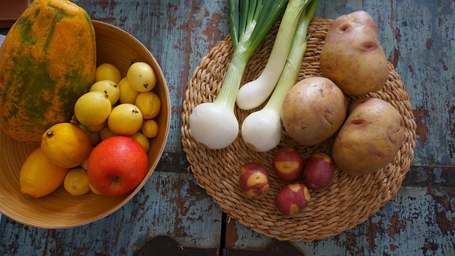 笊の上に載った野菜と果物と芋