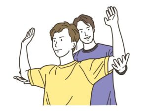 男性クライアントの大胸筋をストレッチする男性トレーナー