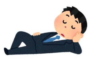 肘を床について横たわるスーツ姿の男性