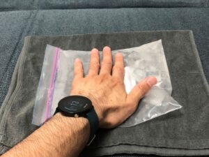 氷水の入ったフリーザーバッグを押しつぶす手