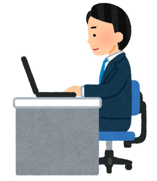 机に座りノートパソコンで作業する男性サラリーマン